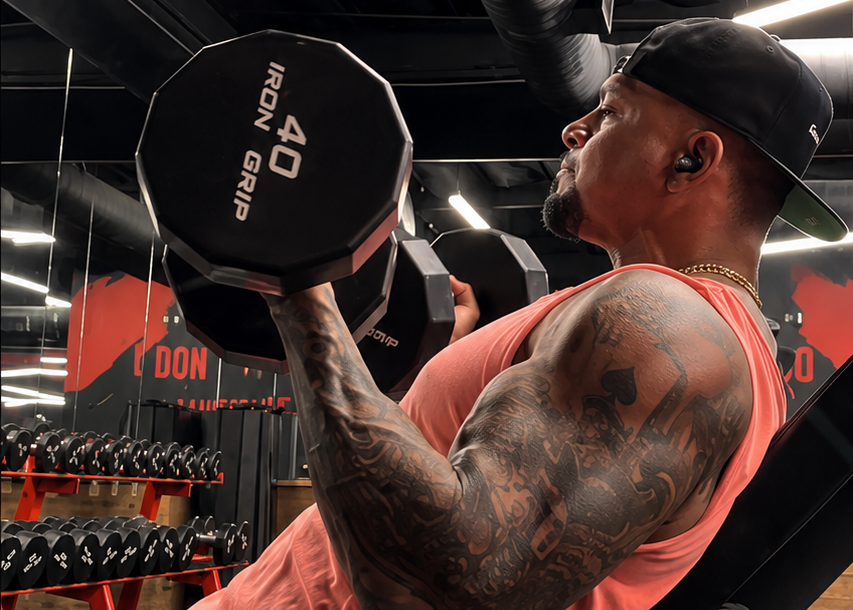 Man performing incline dumbbell curls while training in the gym.
