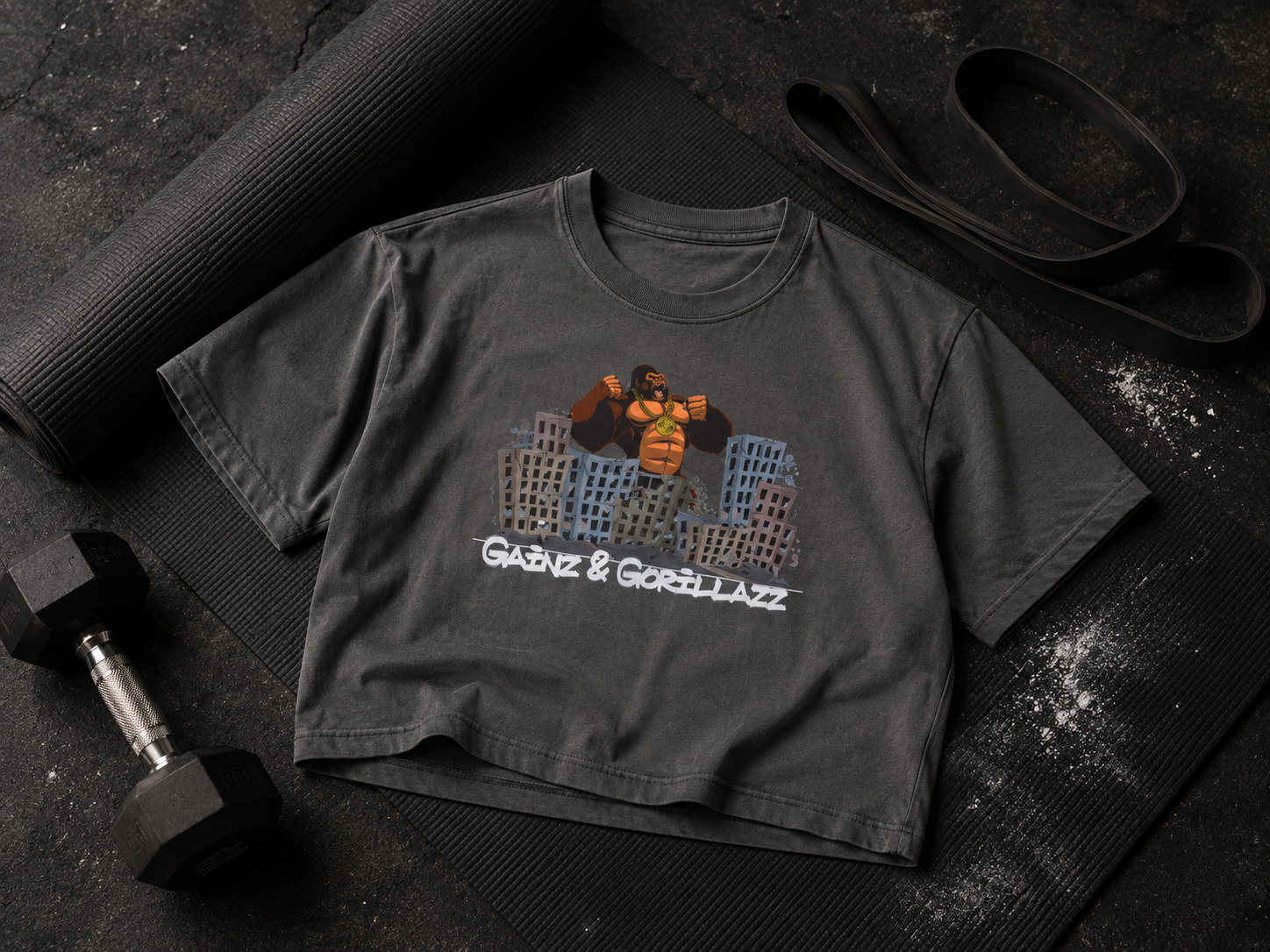 Gainz & Gorillazz OG Gorilla cropped tee styled with a yoga mat, resistance band, and dumbbell